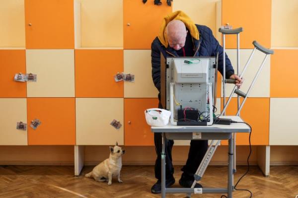 A man, with his dog, votes during the election