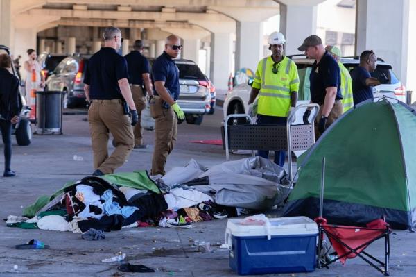 Louisiana State police instruct homeless people in New Orleans to clear out their encampment and move to a different location on Oct. 23, 2024.